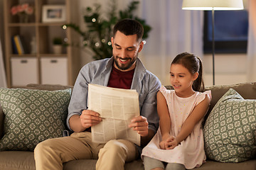 Image showing father reading newspaper to daughter at home
