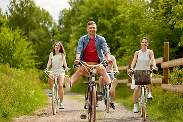 Image showing happy friends riding fixed gear bicycles in summer