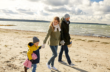 Image showing happy family going to picnic on beach in autumn