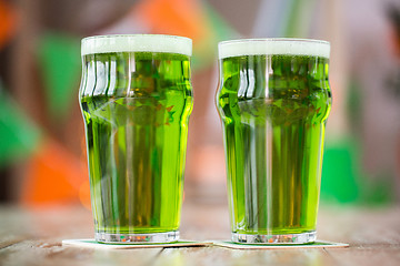 Image showing two glasses of green beer on wooden table