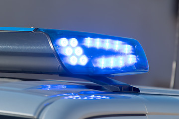 Image showing Detail shot of a glowing blue light on a police car