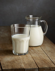 Image showing milk jug and glass on wooden table