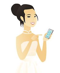 Image showing Young asian fiancee holding a mobile phone.