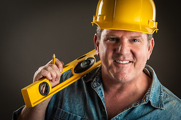 Image showing Smiling Contractor in Hard Hat Holding Level and Pencil With Dra