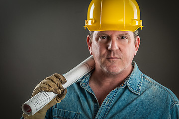 Image showing Serious Contractor in Hard Hat Holding Floor Plans With Dramatic
