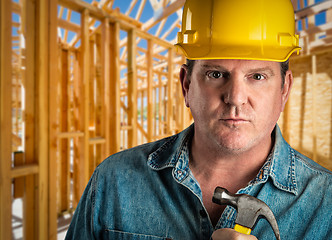 Image showing Serious Contractor in Hard Hat Holding Hammer At Construction Si