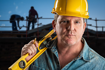 Image showing Serious Contractor in Hard Hat Holding Level and Pencil At Const