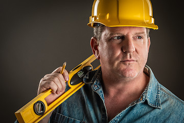 Image showing Serious Contractor in Hard Hat Holding Level and Pencil With Dra