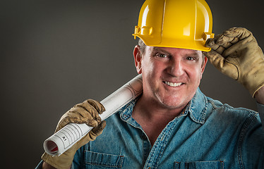 Image showing Smiling Contractor in Hard Hat Holding Floor Plans With Dramatic