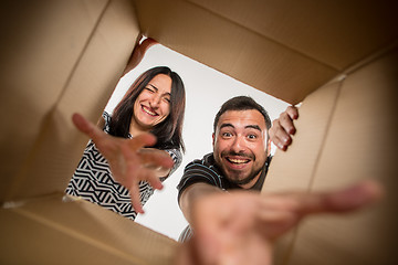 Image showing The couple unpacking and opening carton box and looking inside