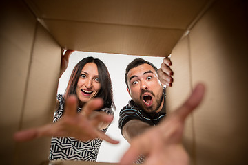 Image showing The couple unpacking and opening carton box and looking inside