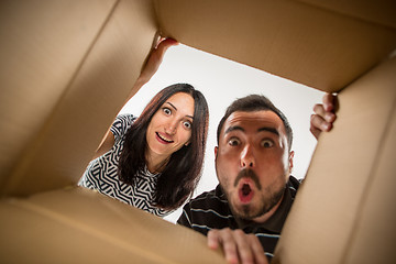 Image showing The couple unpacking and opening carton box and looking inside