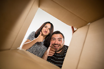 Image showing The couple unpacking and opening carton box and looking inside