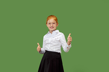 Image showing The happy teen girl standing and smiling against p green background.