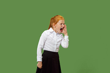 Image showing Isolated on green young casual teen girl shouting at studio