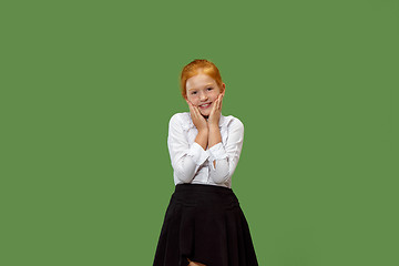 Image showing The happy teen girl standing and smiling against green background.