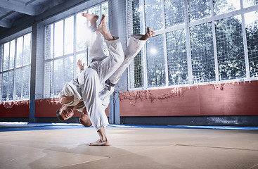 Image showing Two judo fighters showing technical skill while practicing martial arts in a fight club