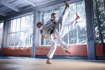 Image showing Two judo fighters showing technical skill while practicing martial arts in a fight club