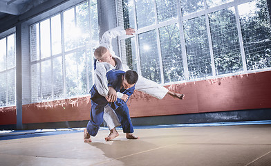 Image showing Two judo fighters showing technical skill while practicing martial arts in a fight club