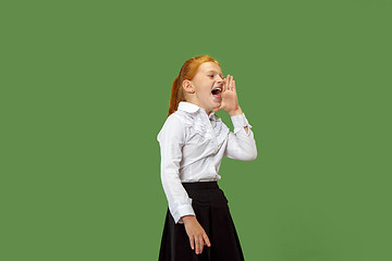 Image showing Isolated on green young casual teen girl shouting at studio