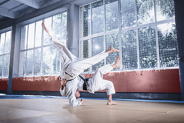 Image showing Two judo fighters showing technical skill while practicing martial arts in a fight club