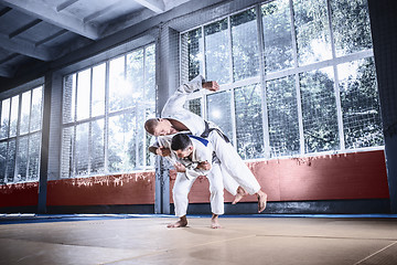 Image showing Two judo fighters showing technical skill while practicing martial arts in a fight club