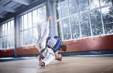 Image showing Two judo fighters showing technical skill while practicing martial arts in a fight club