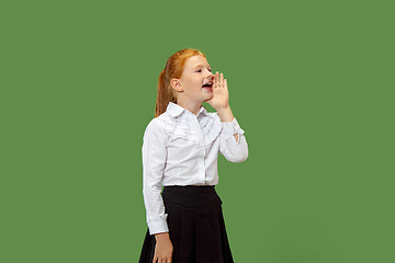 Image showing Isolated on green young casual teen girl shouting at studio