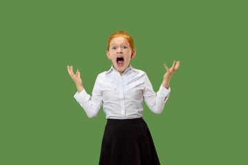 Image showing The young emotional angry teen girl screaming on green studio background