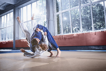 Image showing Two judo fighters showing technical skill while practicing martial arts in a fight club