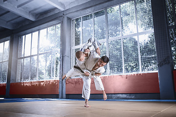 Image showing Two judo fighters showing technical skill while practicing martial arts in a fight club