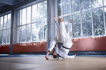 Image showing Two judo fighters showing technical skill while practicing martial arts in a fight club