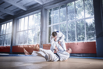 Image showing Two judo fighters showing technical skill while practicing martial arts in a fight club