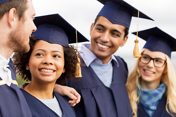 Image showing happy students or bachelors in mortar boards