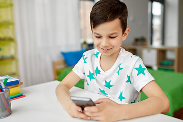 Image showing happy boy with smartphone at home