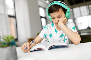 Image showing boy in headphones with textbook learning at home