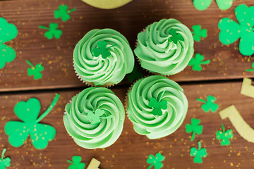 Image showing green cupcakes and shamrock on wooden table