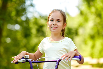 Image showing happy little girl with bicycle in summer