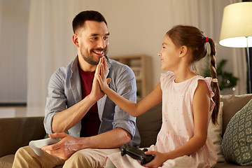 Image showing father and daughter playing video game at home