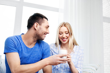 Image showing happy couple sitting on sofa and hugging at home