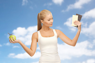 Image showing woman choosing between green apple chocolate