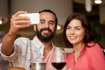 Image showing couple taking selfie by smartphone at restaurant