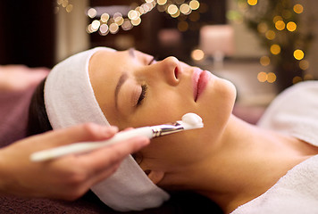 Image showing beautician applying facial mask to woman at spa