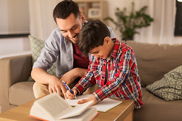 Image showing father and son doing homework together