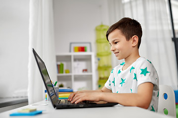 Image showing student boy typing on laptop computer at home