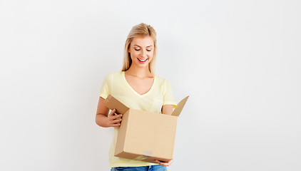 Image showing happy woman looking inside cardboard box