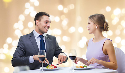 Image showing smiling couple eating main course at restaurant