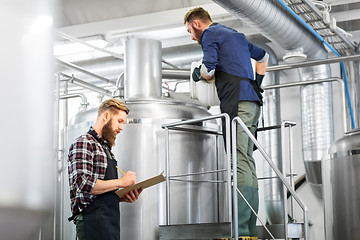 Image showing men with clipboard at brewery kettle or beer plant