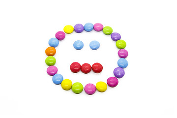 Image showing Smiley from multicolored chocolate glazed candies on white