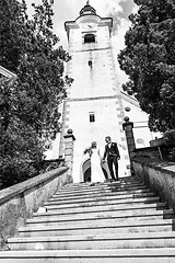 Image showing The Kiss. Bride and groom kisses tenderly on a staircase in front of a small local church.